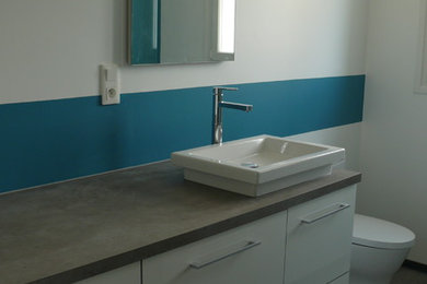 Aménagement d'une petite salle de bain contemporaine avec WC séparés, un mur bleu, un sol en linoléum, un lavabo posé et un plan de toilette en stratifié.