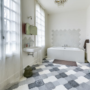 Exemple d'une salle de bain principale méditerranéenne de taille moyenne avec une baignoire indépendante, un carrelage blanc, un mur blanc et un lavabo suspendu.