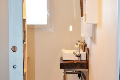 Cette photo montre une petite salle de bain principale tendance avec une douche à l'italienne, WC suspendus, un carrelage noir, des carreaux de céramique, un mur gris, sol en béton ciré, un plan de toilette en bois et une grande vasque.