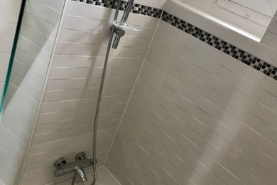 Exemple d'une salle de bain principale chic de taille moyenne avec une baignoire encastrée, un carrelage blanc, des carreaux de porcelaine et un mur blanc.