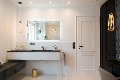 Exemple d'une salle de bain tendance avec des portes de placard noires, une douche à l'italienne, un carrelage blanc, des carreaux de céramique, un lavabo encastré, un plan de toilette en surface solide et un plan de toilette noir.