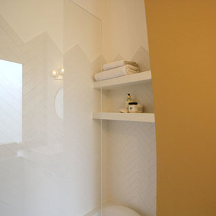 Idée de décoration pour une petit salle de bain vintage avec un placard à porte affleurante, des portes de placard blanches, une baignoire encastrée, un espace douche bain, un carrelage blanc, des carreaux en allumettes, un mur jaune, un sol en carreaux de ciment, un lavabo posé, un plan de toilette en bois et un sol jaune.