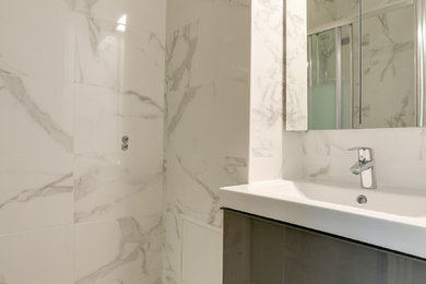 Cette image montre une petite salle d'eau avec des portes de placard grises, un carrelage blanc, carreaux de ciment au sol, une vasque et un sol gris.