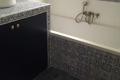 Aménagement d'une salle de bain principale contemporaine de taille moyenne avec une baignoire encastrée, un mur blanc, carreaux de ciment au sol et un sol noir.
