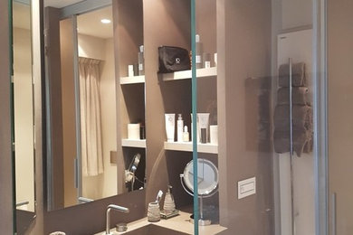Immagine di una piccola stanza da bagno con doccia design con doccia ad angolo, piastrelle beige, pareti beige, top in superficie solida e porta doccia scorrevole