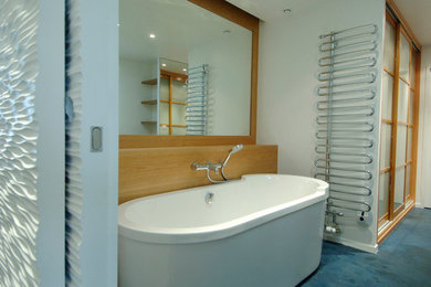 На фото: большая главная ванная комната в стиле модернизм с душем в нише, раздельным унитазом, бетонным полом, раковиной с пьедесталом, столешницей из дерева, синим полом, душем с раздвижными дверями и накладной ванной с