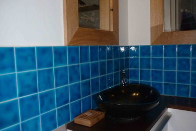 Inspiration pour une petite salle de bain traditionnelle avec un carrelage bleu, des carreaux de porcelaine, un mur blanc, une vasque et un plan de toilette en bois.
