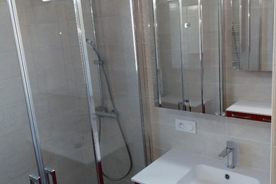 Aménagement d'une grande salle de bain classique avec une douche à l'italienne, un carrelage beige, des carreaux de céramique, un mur beige, un sol en carrelage de céramique, un lavabo encastré, un plan de toilette en surface solide, un sol gris et une cabine de douche à porte battante.