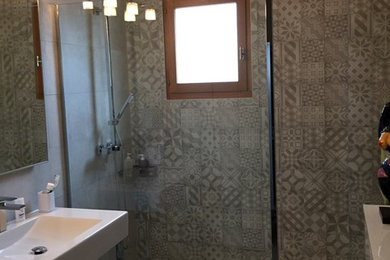 Foto di una piccola stanza da bagno con doccia con doccia a filo pavimento, piastrelle grigie, piastrelle di cemento, pareti grigie, pavimento con piastrelle in ceramica e pavimento grigio