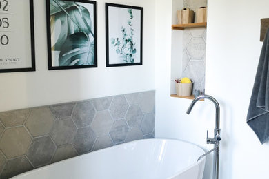 Idées déco pour une salle d'eau contemporaine avec une baignoire indépendante, un carrelage gris, un mur blanc et un plan vasque.