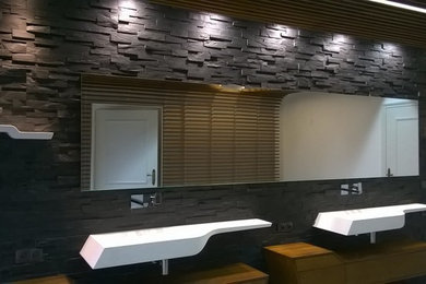Imagen de cuarto de baño principal moderno grande con bañera encastrada sin remate, baldosas y/o azulejos negros, losas de piedra, paredes negras, suelo de baldosas de cerámica y lavabo suspendido
