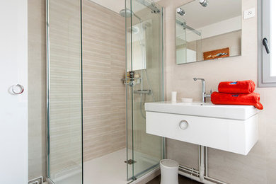 Cette image montre une salle de bain principale design de taille moyenne avec une douche d'angle, un carrelage beige, un mur beige, un lavabo suspendu, un sol gris, une cabine de douche à porte coulissante, un plan de toilette blanc, des portes de placard blanches et un sol en carrelage de porcelaine.