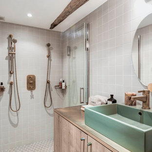 Cette image montre une petit salle de bain principale rustique avec un placard à porte affleurante, des portes de placard marrons, une douche à l'italienne, un WC séparé, un carrelage blanc, un carrelage gris, des carreaux de céramique, un mur gris, un sol en carrelage de porcelaine, un lavabo intégré, un plan de toilette en bois et un plan de toilette marron.