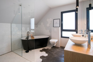 Réalisation d'une salle de bain principale design de taille moyenne avec une baignoire posée, une douche à l'italienne, WC suspendus, des carreaux de céramique, un mur gris, sol en béton ciré, un plan vasque, un sol gris et aucune cabine.