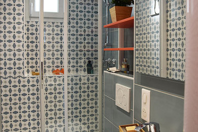 パリにある高級な小さなモダンスタイルのおしゃれなマスターバスルーム (壁掛け式トイレ、青いタイル、セラミックタイル、マルチカラーの壁、セラミックタイルの床、一体型シンク、青い床、引戸のシャワー) の写真