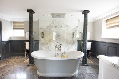 Aménagement d'une salle de bain principale classique avec un placard avec porte à panneau surélevé, des portes de placard grises, une baignoire indépendante, une douche ouverte, un carrelage gris, un carrelage de pierre, un mur gris, un sol en marbre et un lavabo intégré.