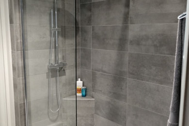 Réalisation d'une salle de bain principale design de taille moyenne avec une douche à l'italienne, un carrelage gris, des carreaux de céramique, un mur gris, un sol en carrelage de céramique, un sol gris et un plan de toilette blanc.