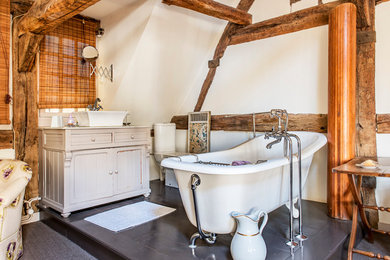 Exemple d'une salle de bain principale nature de taille moyenne avec un placard en trompe-l'oeil, des portes de placard beiges, une baignoire sur pieds, un mur blanc, une vasque et WC séparés.