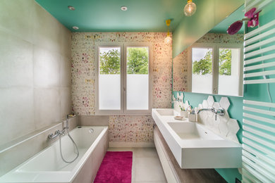 Réalisation d'une salle de bain principale design de taille moyenne avec une baignoire posée, un carrelage beige, des carreaux de céramique, un mur multicolore, un sol en carrelage de céramique, un lavabo suspendu, un sol beige et un plan de toilette blanc.