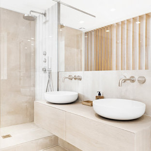 Idéer för att renovera ett mellanstort funkis en-suite badrum, med en kantlös dusch, en toalettstol med separat cisternkåpa, beige kakel, vit kakel, beige väggar, travertin golv, ett fristående handfat och kaklad bänkskiva
