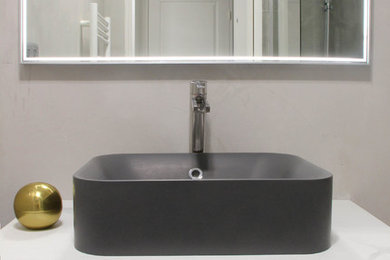 Immagine di una piccola stanza da bagno padronale contemporanea con vasca sottopiano, vasca/doccia, piastrelle grigie, pareti grigie, pavimento in marmo, lavabo a consolle e top in marmo