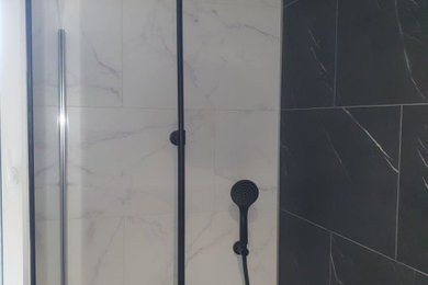 Exemple d'une salle de bain moderne de taille moyenne avec des portes de placard noires, une douche ouverte, du carrelage en marbre, un sol en marbre, une vasque, un sol noir, un plan de toilette blanc, meuble double vasque et meuble-lavabo sur pied.