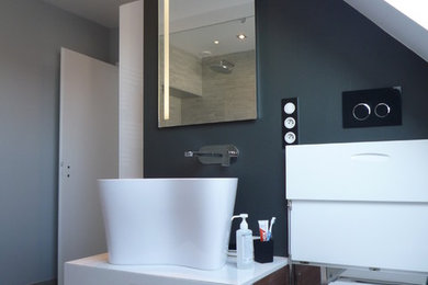 Diseño de cuarto de baño principal contemporáneo de tamaño medio con ducha abierta, sanitario de pared, baldosas y/o azulejos grises, paredes grises, lavabo de seno grande, encimera de madera y suelo gris