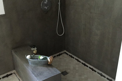Aménagement d'une petite salle d'eau méditerranéenne avec une douche à l'italienne, un carrelage beige, un carrelage de pierre et un mur gris.