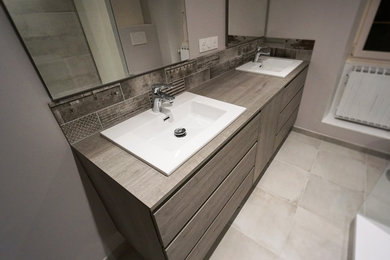 Cette image montre une salle de bain principale design de taille moyenne avec un placard à porte plane, une douche ouverte, WC suspendus et un plan de toilette en bois.