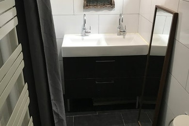 Exemple d'une petite salle de bain principale tendance avec un placard à porte affleurante, une douche d'angle, un bidet, un carrelage blanc, un mur blanc, carreaux de ciment au sol, un sol noir et une cabine de douche à porte coulissante.