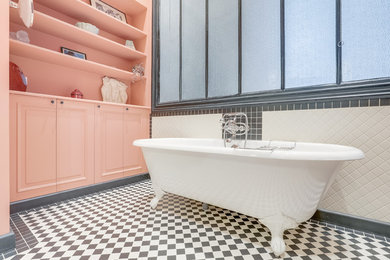 This is an example of a medium sized traditional ensuite bathroom in Grenoble with beaded cabinets, orange cabinets, a claw-foot bath, an alcove shower, white tiles, metro tiles, orange walls, cement flooring, a console sink, solid surface worktops, black floors, a hinged door and white worktops.