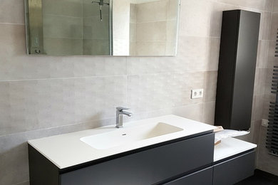 Inspiration pour une salle de bain minimaliste de taille moyenne avec un bain bouillonnant, une douche à l'italienne, un carrelage gris, des carreaux de céramique, un mur gris et un plan de toilette en surface solide.