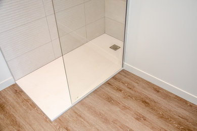 Idée de décoration pour une salle de bain principale minimaliste de taille moyenne avec une douche d'angle, WC séparés, un carrelage beige, un sol en vinyl, un plan vasque, un sol marron et meuble simple vasque.