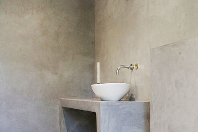Aménagement d'une salle de bain contemporaine avec un plan de toilette en béton.