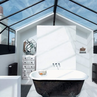Design ideas for a mid-sized eclectic master bathroom in Grenoble with distressed cabinets, a claw-foot tub, white walls and painted wood floors.