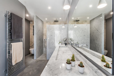 Aménagement d'une grande salle de bain avec une douche à l'italienne, WC suspendus, un mur blanc, sol en béton ciré, une grande vasque, un sol gris et aucune cabine.