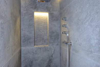 Inspiration pour une salle de bain design avec un carrelage gris, un mur gris et un sol gris.