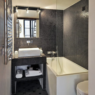 Idées déco pour une petit salle de bain principale contemporaine avec une vasque, un plan de toilette en carrelage, un combiné douche/baignoire, un carrelage noir, carrelage en mosaïque et un mur blanc.