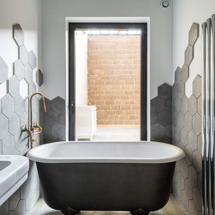 Aménagement d'une petit salle de bain principale contemporaine avec une baignoire sur pieds, un carrelage gris, un mur blanc, béton au sol et un lavabo suspendu.