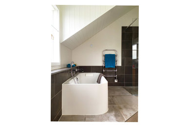 Exemple d'une salle de bain moderne avec une baignoire indépendante, une douche à l'italienne, WC suspendus, des carreaux de porcelaine, un mur gris, un sol en carrelage de porcelaine et un lavabo encastré.