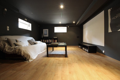 Mittelgroßes, Abgetrenntes Modernes Heimkino mit schwarzer Wandfarbe, hellem Holzboden, Leinwand und beigem Boden in Marseille