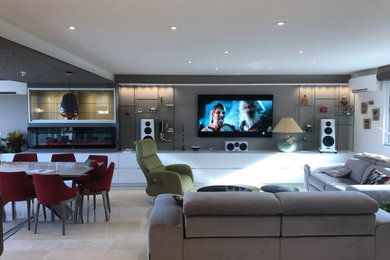 Foto de cine en casa abierto contemporáneo grande con suelo de mármol, televisor colgado en la pared y suelo beige