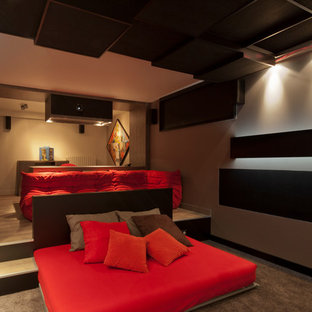 Idées déco pour une grand salle de cinéma contemporaine fermée avec un mur beige, moquette, un écran de projection et un sol marron.