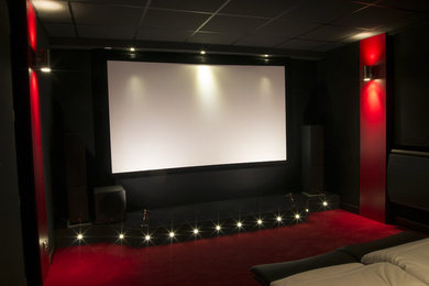 Réalisation d'une salle de cinéma tradition de taille moyenne et fermée avec moquette et un écran de projection.