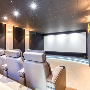Cette photo montre une salle de cinéma tendance fermée avec un mur noir, moquette, un écran de projection et un sol beige.