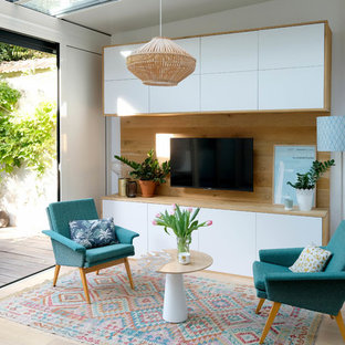 Inspiration pour une salle de séjour nordique de taille moyenne et ouverte avec un mur blanc, un sol en bois clair, un téléviseur fixé au mur et un sol beige.