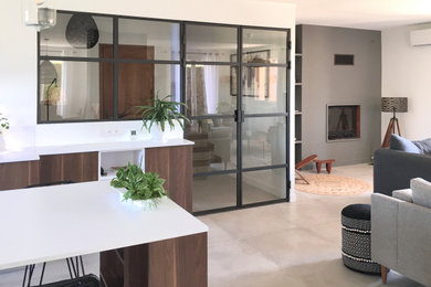 Exemple d'une salle de séjour tendance avec un mur gris, un sol en carrelage de céramique, un manteau de cheminée en plâtre et un sol gris.