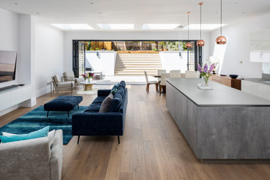 Großes, Offenes Modernes Wohnzimmer ohne Kamin mit weißer Wandfarbe, hellem Holzboden, TV-Wand und braunem Boden in Nizza