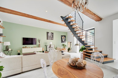 Inspiration pour une salle de séjour design de taille moyenne et ouverte avec un mur vert, un sol en carrelage de céramique, un téléviseur fixé au mur, un sol blanc et poutres apparentes.