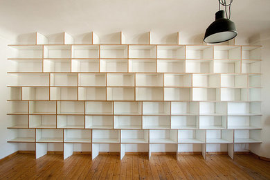 Immagine di un grande soggiorno minimal aperto con libreria, pareti bianche, parquet scuro, nessuna TV e pavimento marrone